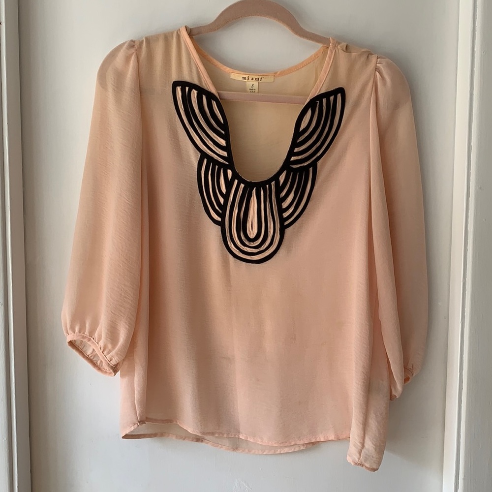 Light pink top with black detailing on the neckline, lightweight material!